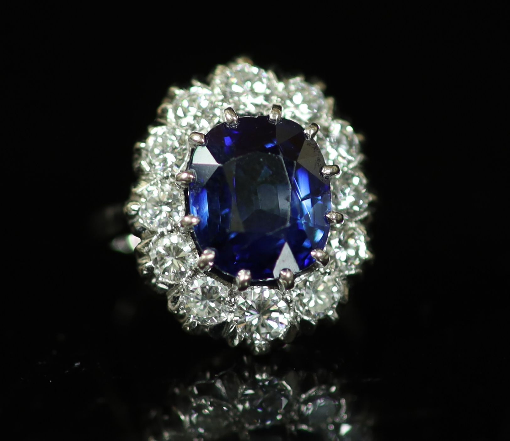 A modern 18ct white gold, sapphire and diamond set oval cluster ring, by Garrard & Co